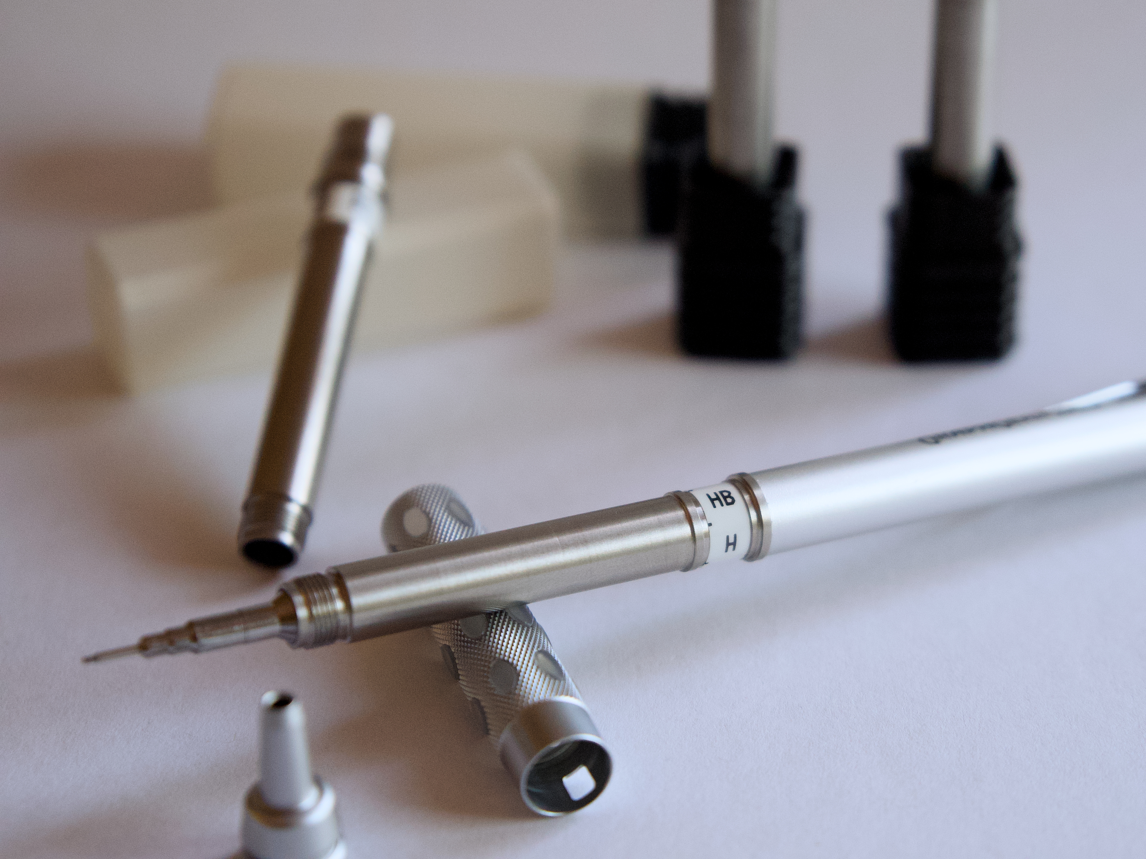 Stainless steel pencil parts arranged around an assembled mechanical pencil