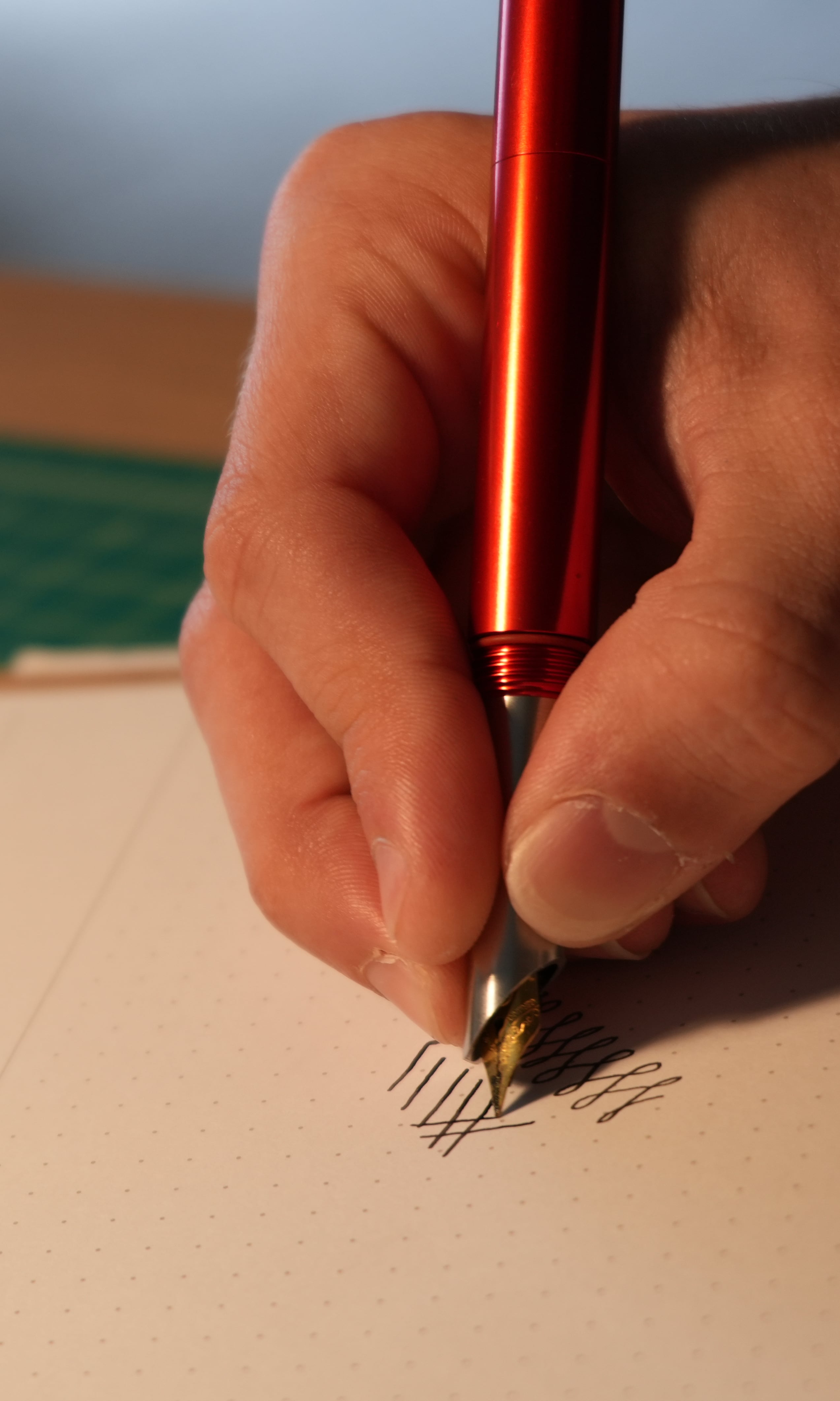 Writing with a red fountain pen.