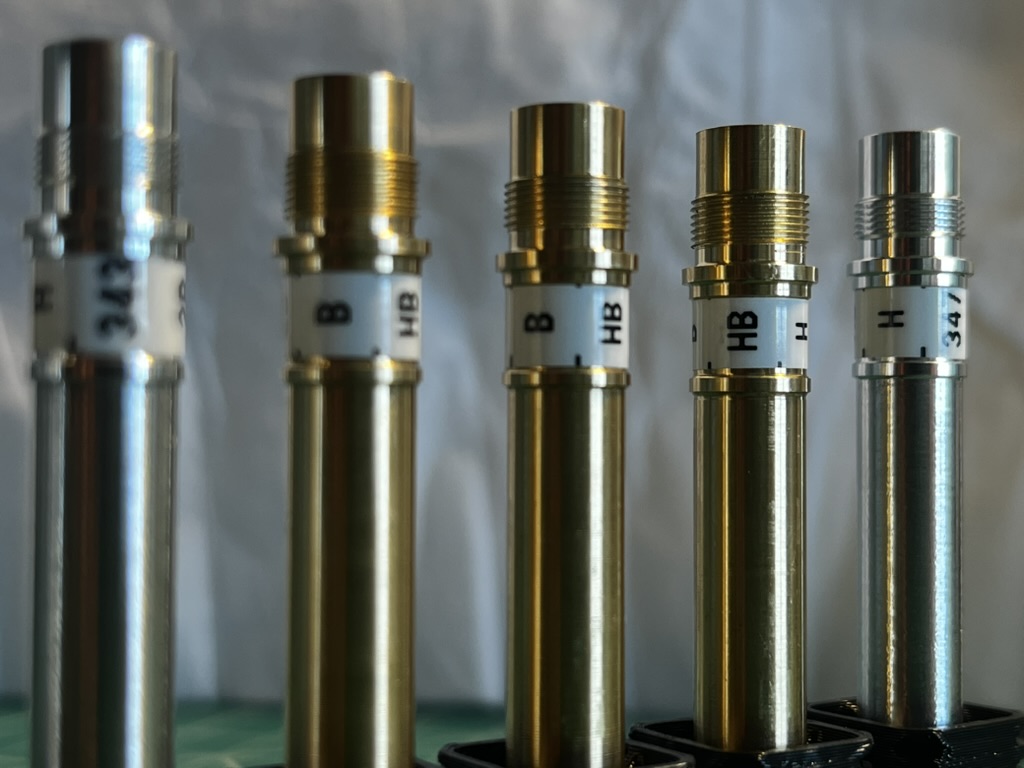 3 Brass Pencil Parts in black plastic boxes.