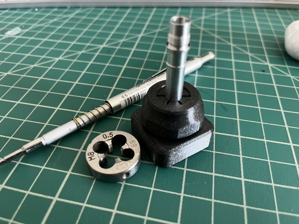 A plastic collet block next to a mechanical pencil