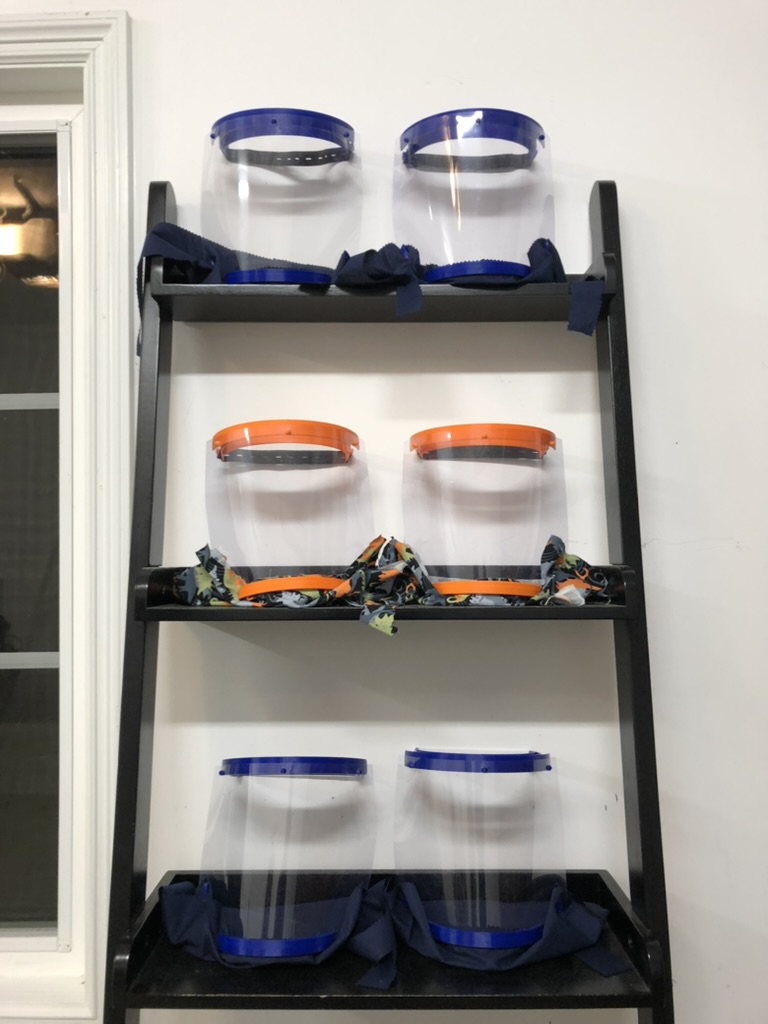 6 draped faceshields sitting on a shelf